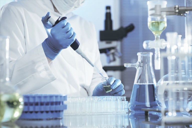 KEYENCE Mikroskop Laboratory chemist using a pipette to fill liquid into a test tube